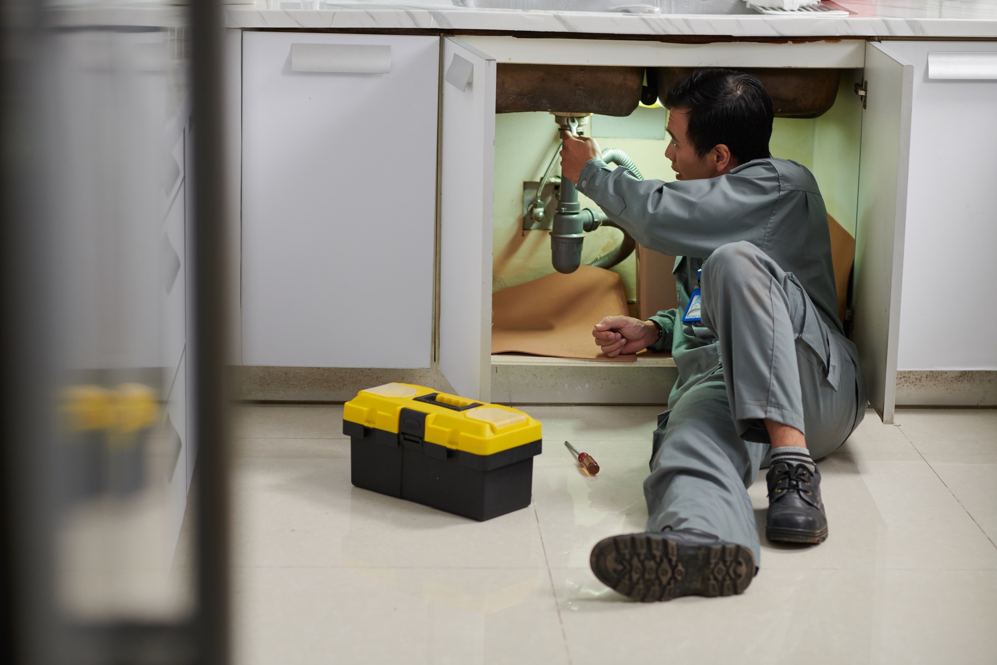 Plumber Fixing Leaking Sink